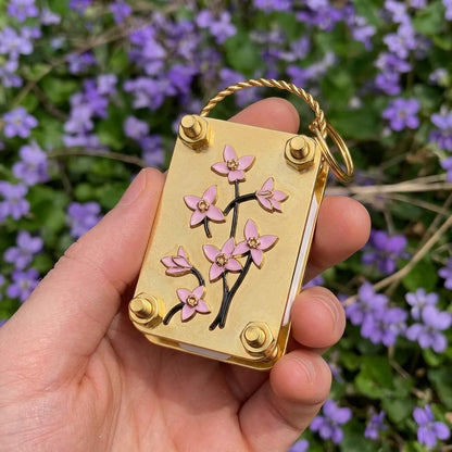 Hand holding the Bloomkept mini flower press among wildflowers
